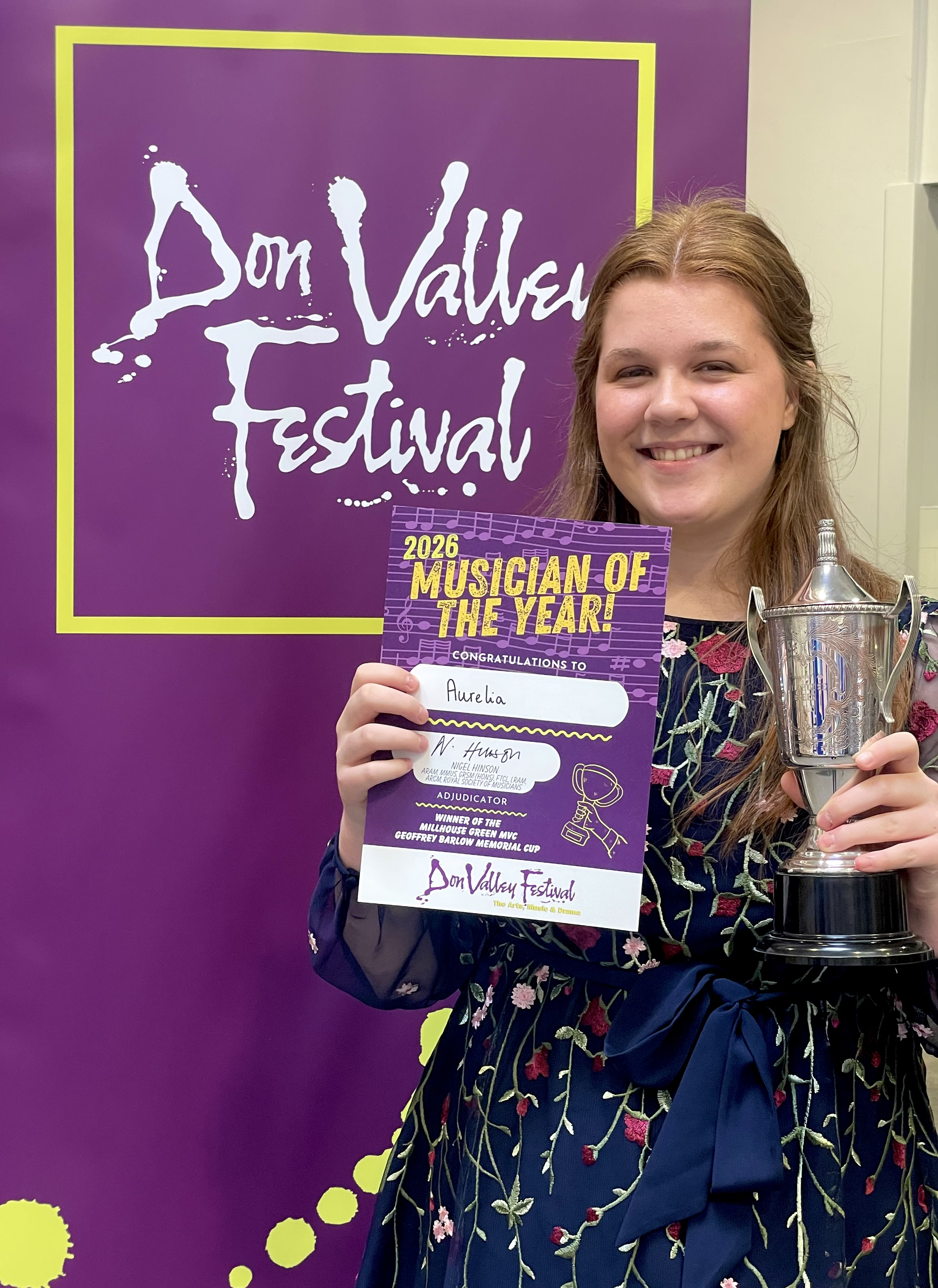 Aurelia holding her 2026 Musician of the Year certificate and trophy.