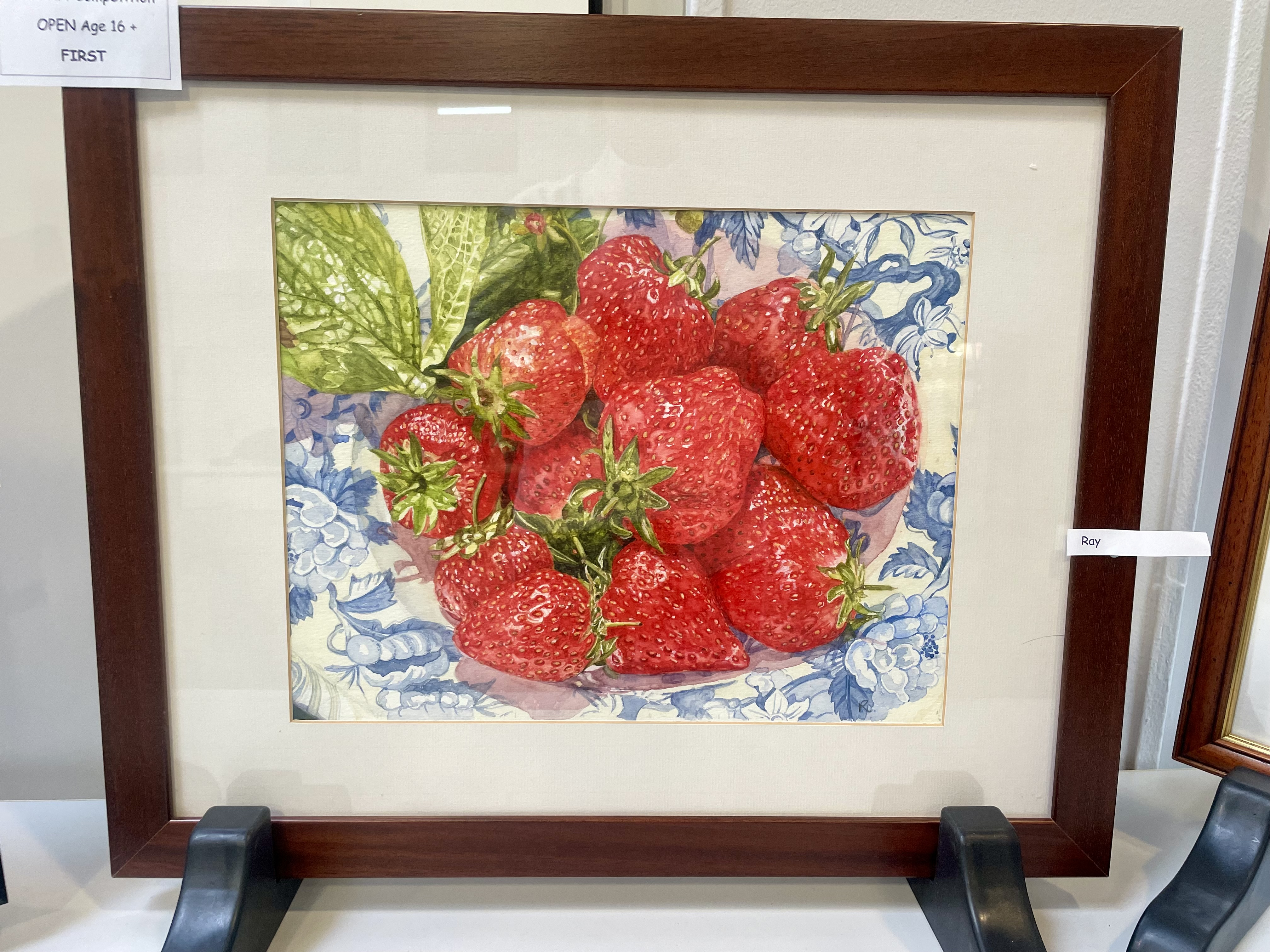 Ray’s winning artwork, a detailed painting of strawberries in a patterned bowl.